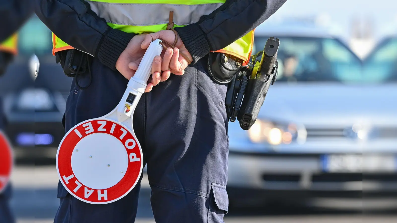 Ein Polizeibeamter hält eine Winkerkelle in den Händen. Auch an der Grenze zwischen Bayern und Tschechien führt die Bundespolizei nun stationäre Grenzkontrollen durch. Genaue Angaben zu Orten oder Zeiten gab es vorerst nicht.  (Symbolbild: Patrick Pleul/dpa)